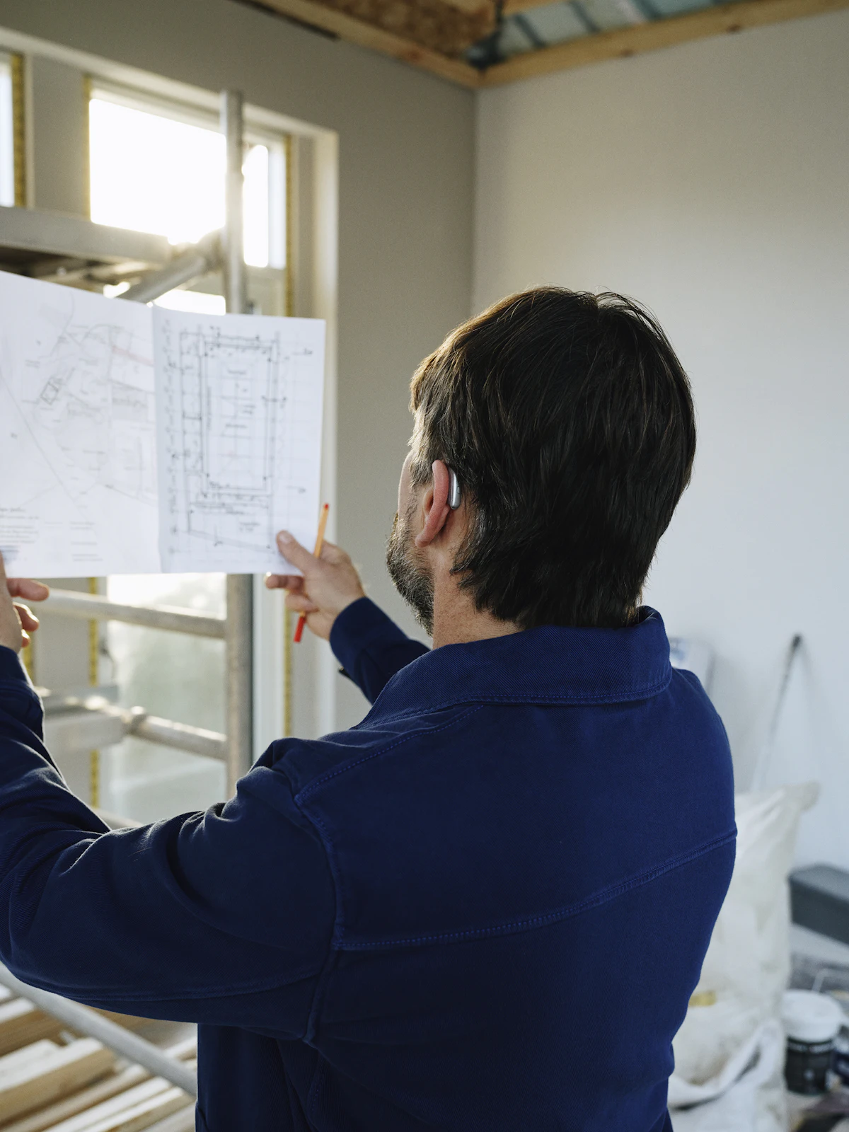 A builder reviewing plans on site during a custom home build