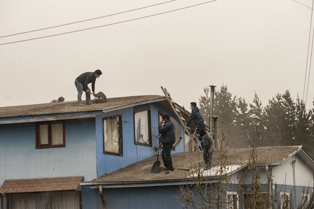 A restoration crew clearing storm damage from a home